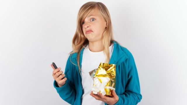 Foto: Shutterstock. Bilde av jente med grimase etter å ha mottar en gave som er feil.